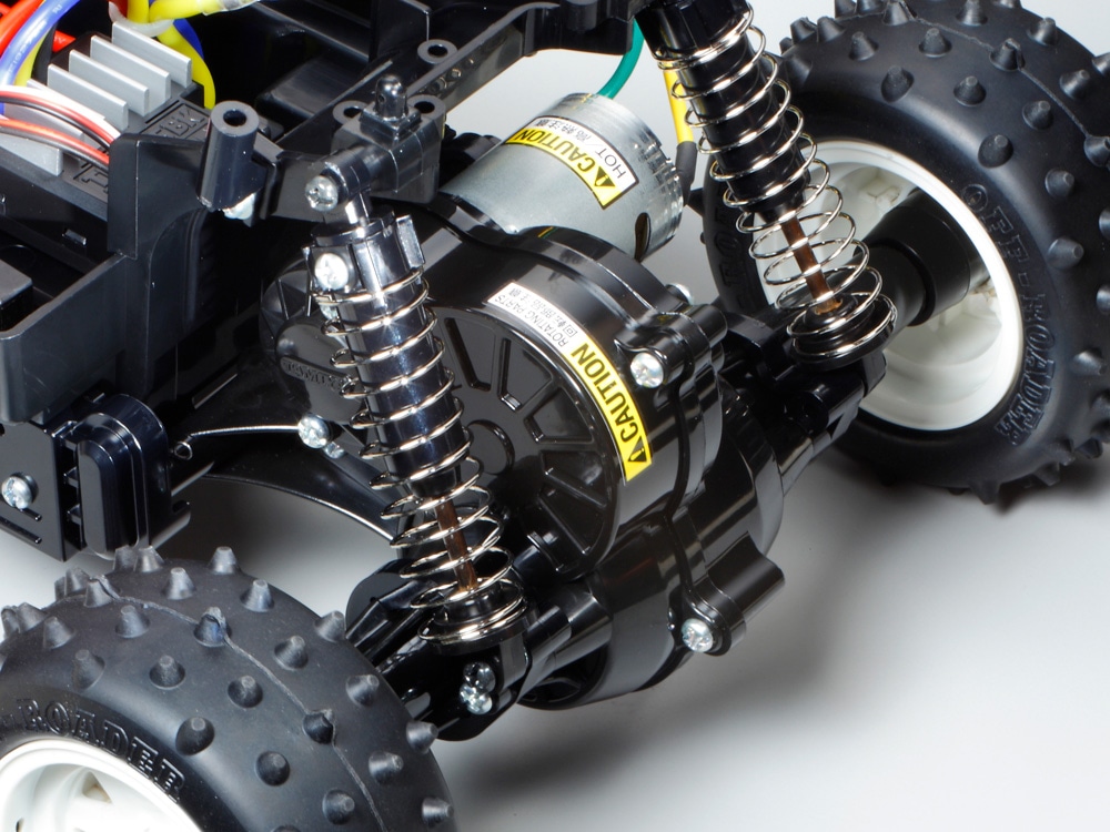 Tamiya official rear-gearbox view: the supplied 380 motor and rolling rear assembly, with electronics illustrating a completed build.
